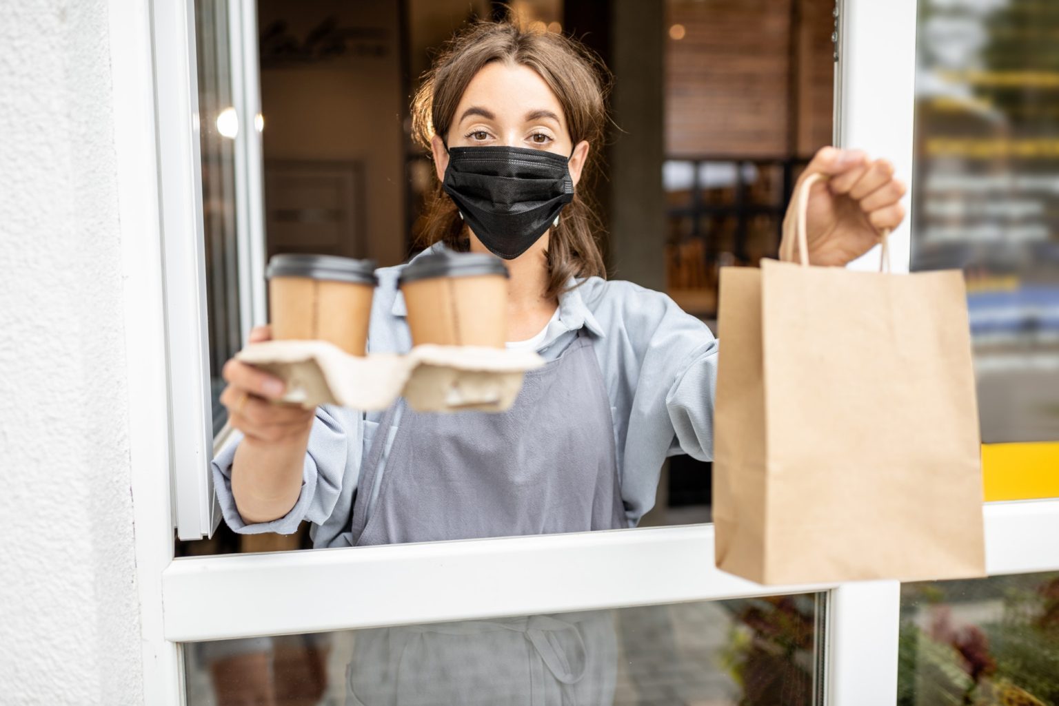 Woman with food to take away in the shop window