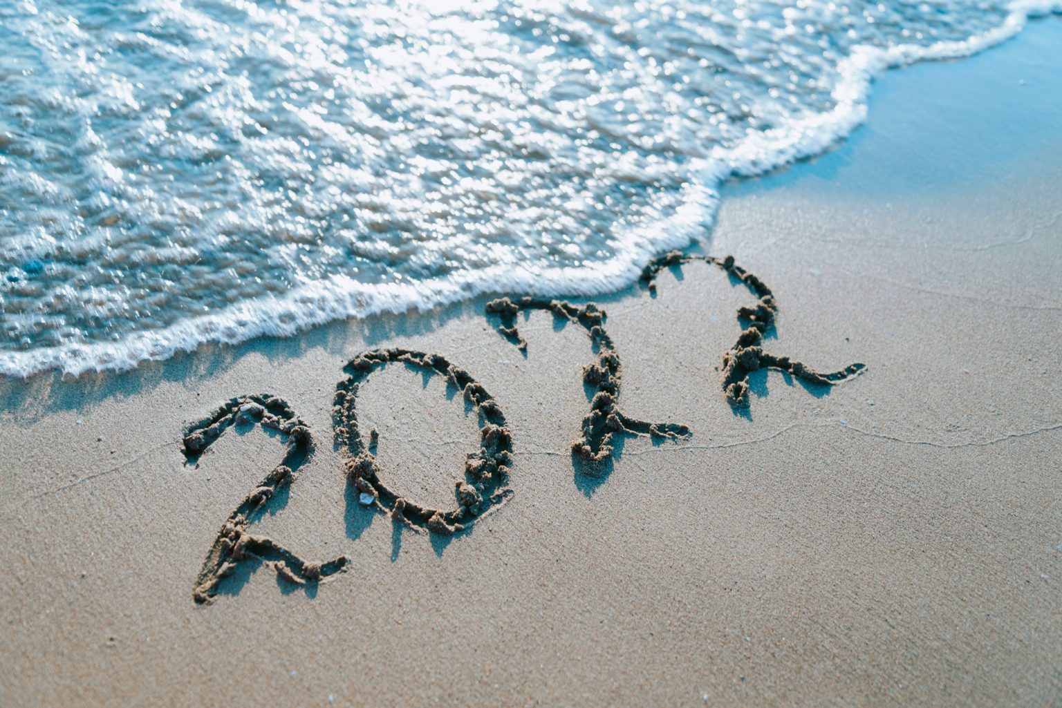 Inscription 2022 on sand by the sea